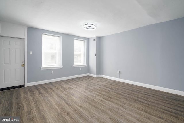 unfurnished room with dark hardwood / wood-style flooring