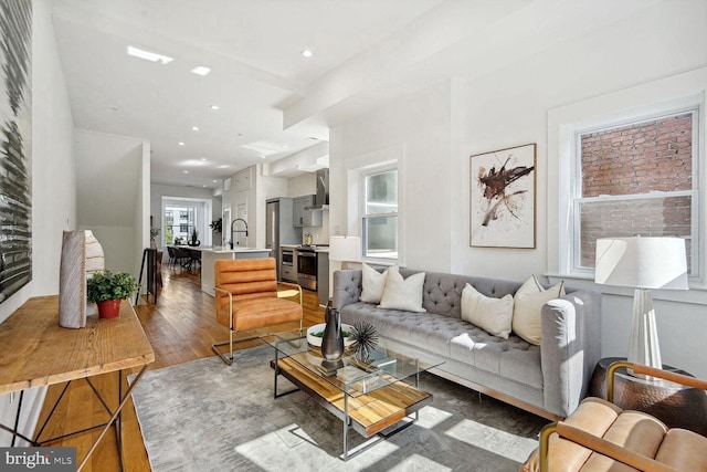 living room with hardwood / wood-style flooring and sink