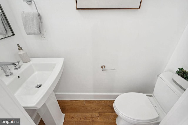 bathroom featuring toilet, hardwood / wood-style floors, and sink