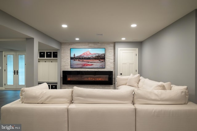 home theater room with a large fireplace, wood-type flooring, and french doors