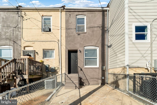 back of house with central air condition unit and a wooden deck