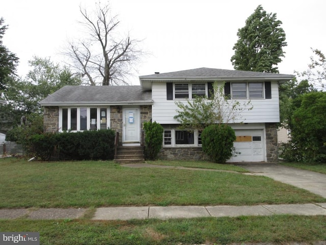 split level home with a front lawn and a garage