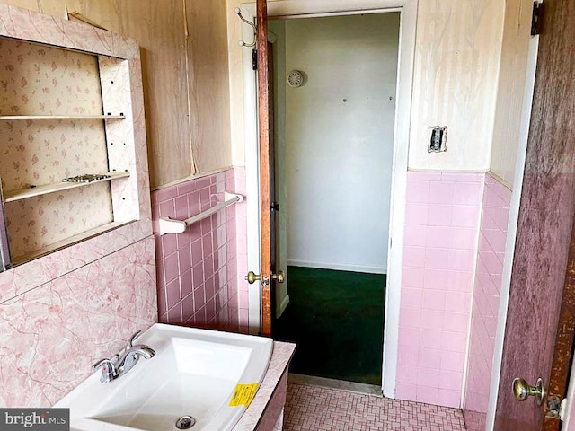 bathroom with tile patterned floors, sink, and tile walls