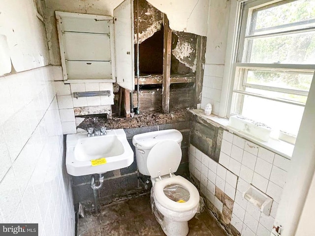 bathroom with sink, tile walls, and toilet