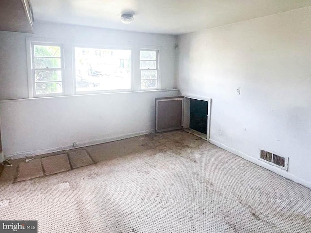 carpeted spare room featuring a healthy amount of sunlight