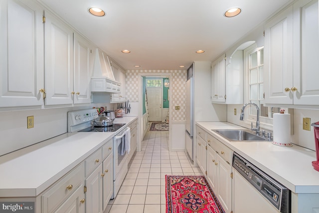 kitchen with premium range hood, white appliances, sink, and white cabinets