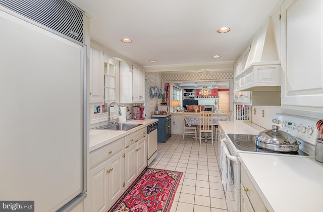 kitchen with sink, paneled fridge, custom range hood, white range with electric cooktop, and white cabinets