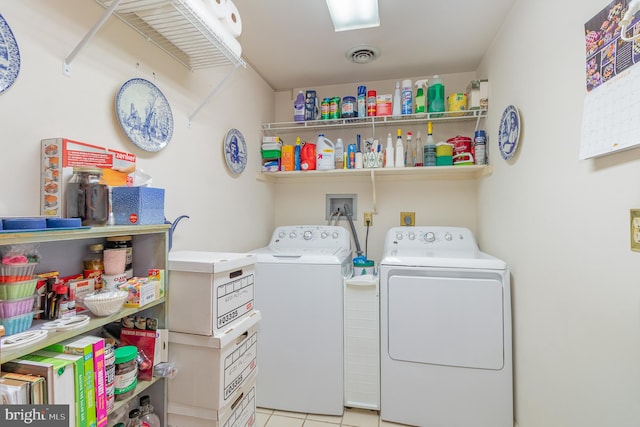 clothes washing area featuring separate washer and dryer and light tile patterned floors