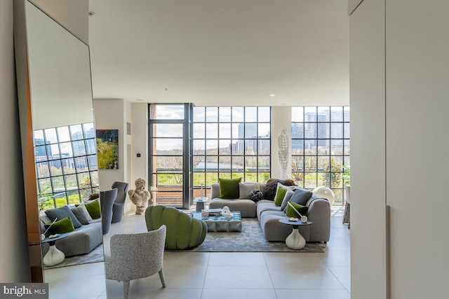 living room featuring a wall of windows, a water view, and light tile patterned floors