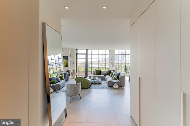 hall with a wall of windows and light tile patterned floors