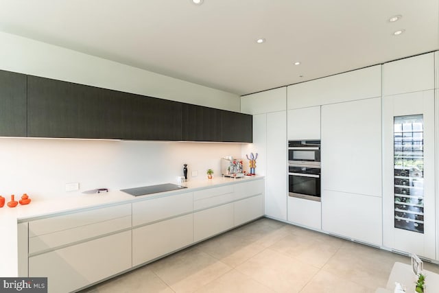 kitchen featuring light tile patterned flooring, black appliances, and white cabinetry