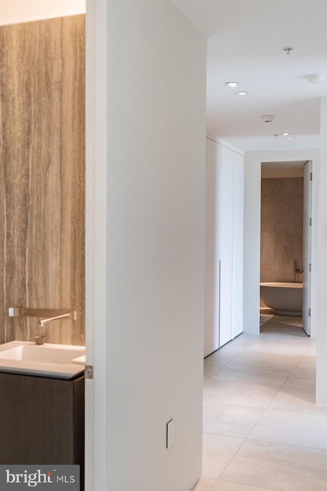 hallway featuring light tile patterned flooring and sink