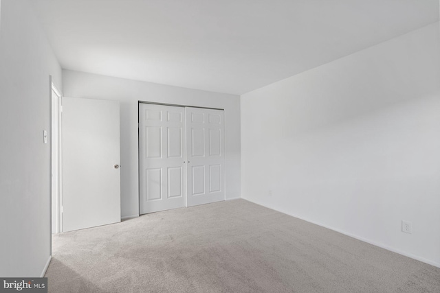 unfurnished bedroom with a closet and carpet