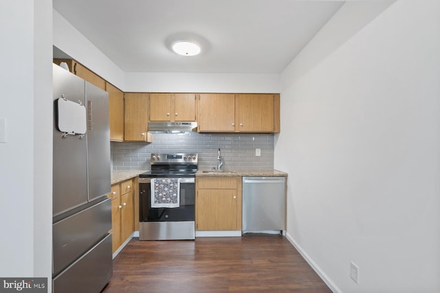 kitchen with sink, dark wood-type flooring, stainless steel appliances, tasteful backsplash, and light stone counters