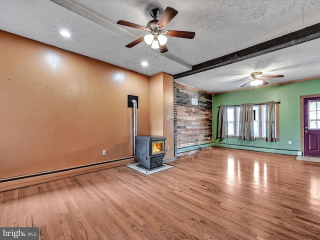 unfurnished living room featuring a baseboard radiator, hardwood / wood-style floors, and a textured ceiling