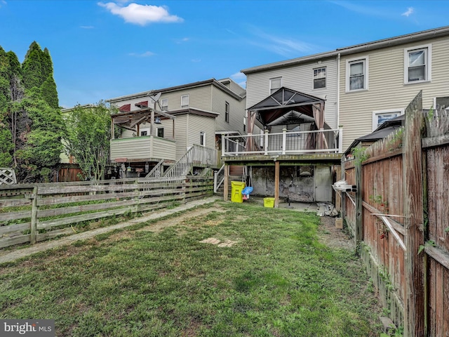 rear view of property with a deck and a yard