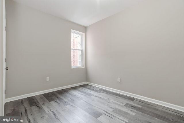 unfurnished room with vaulted ceiling and hardwood / wood-style floors