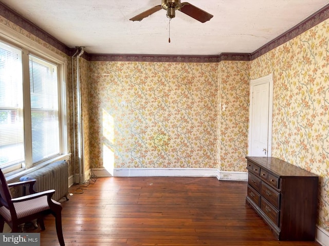 interior space featuring radiator, ceiling fan, ornamental molding, and dark hardwood / wood-style flooring