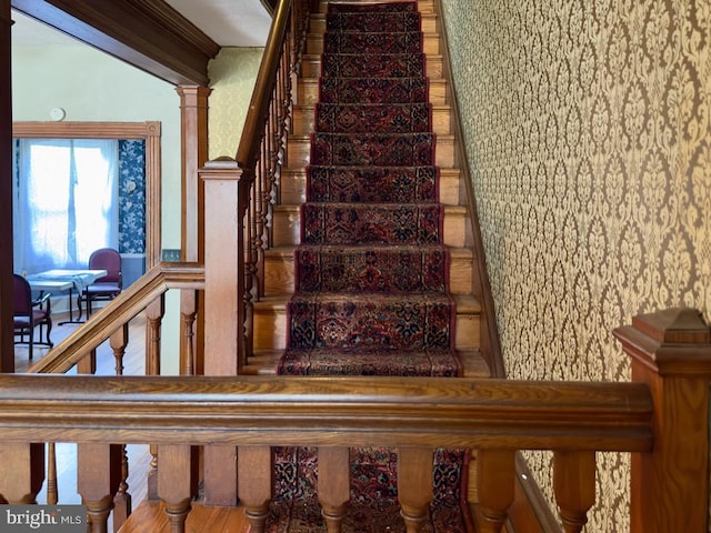 stairs with ornate columns and hardwood / wood-style flooring