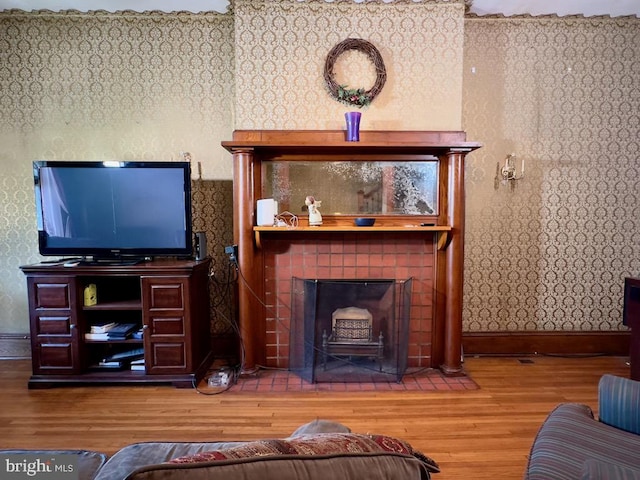 living room featuring a tiled fireplace and wood-type flooring