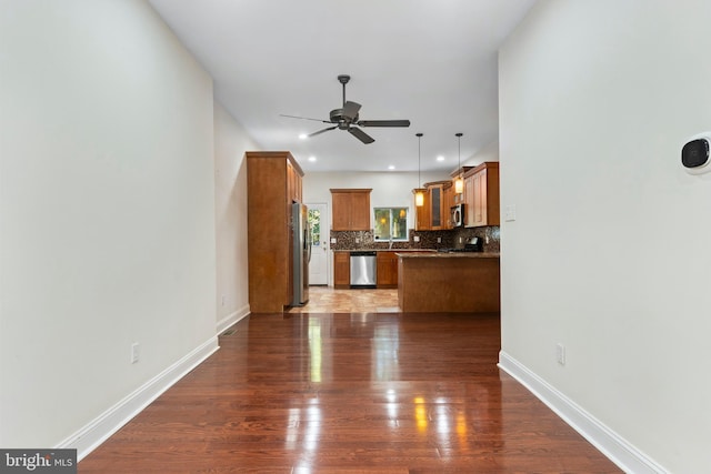 unfurnished living room featuring ceiling fan and dark wood-type flooring