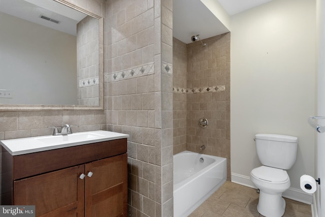 full bathroom featuring vanity, tiled shower / bath combo, tile patterned flooring, tile walls, and toilet