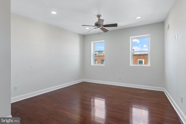 empty room with ceiling fan, plenty of natural light, and dark wood-type flooring