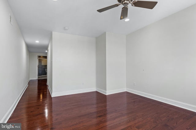 spare room with dark wood-type flooring and ceiling fan