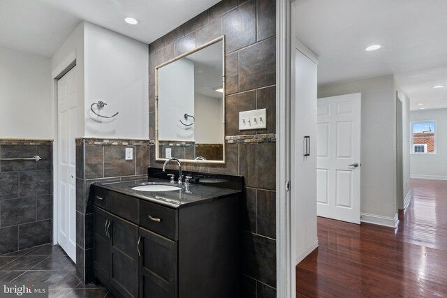 bathroom with vanity, hardwood / wood-style flooring, and tile walls