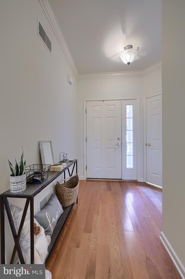 entryway with light hardwood / wood-style flooring and ornamental molding