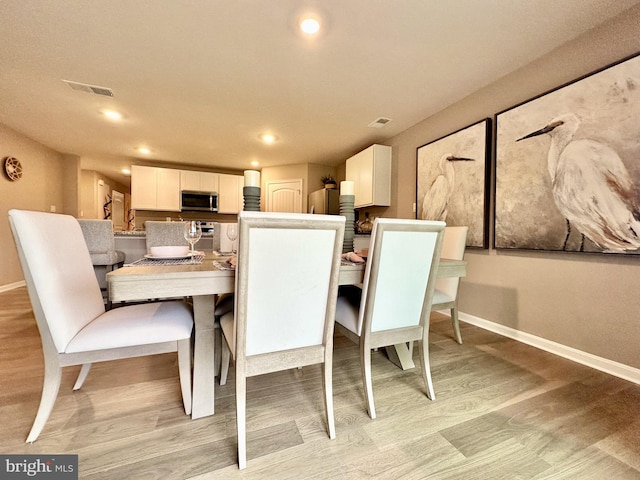 dining space featuring light wood-type flooring