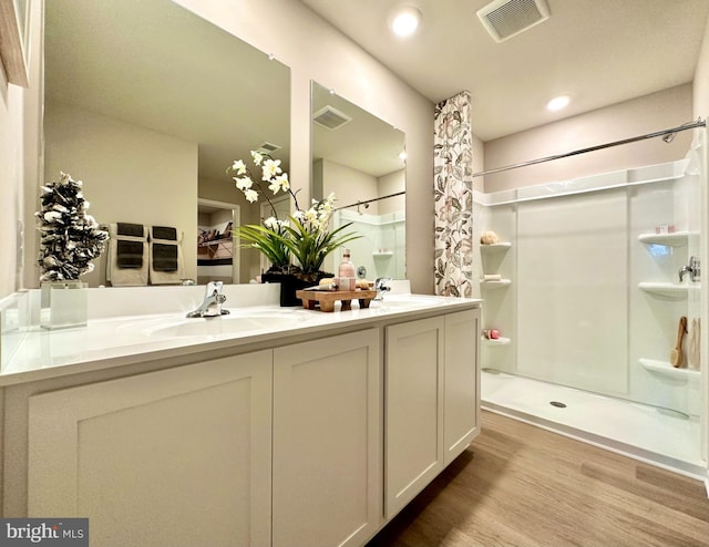 bathroom with walk in shower, hardwood / wood-style flooring, and vanity