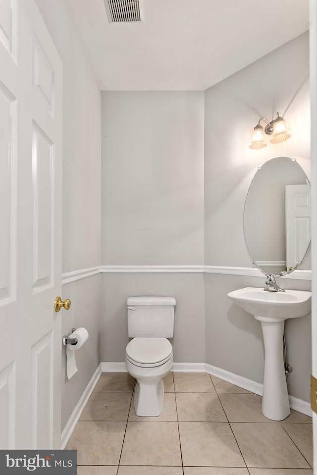 bathroom with toilet and tile patterned floors