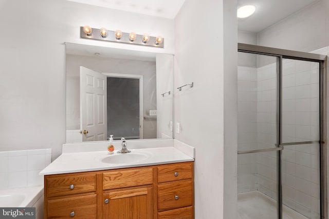 bathroom with a shower with shower door and vanity