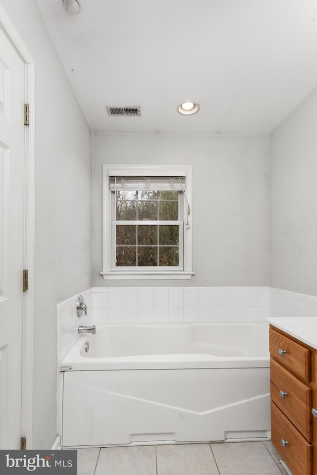 bathroom with vanity, a tub, and tile patterned flooring