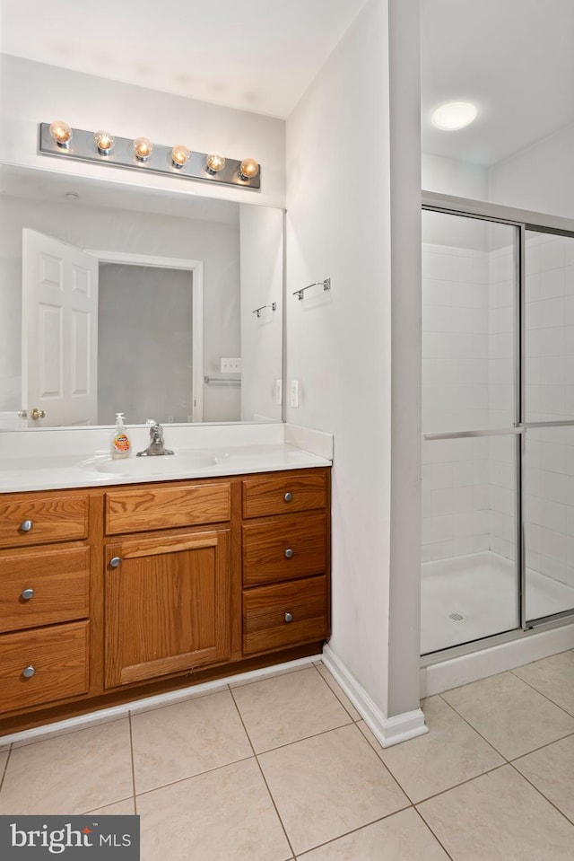 bathroom featuring vanity, a shower with door, and tile patterned flooring