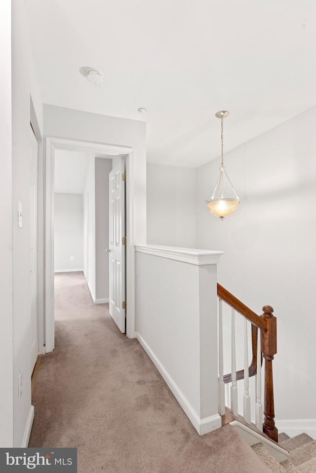 hallway featuring light colored carpet