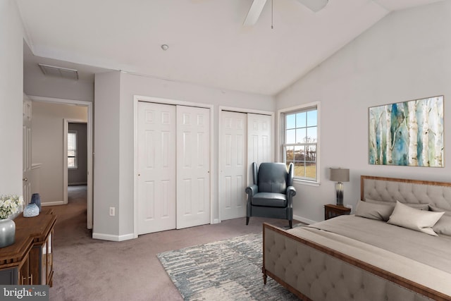 bedroom with two closets, ceiling fan, vaulted ceiling, and carpet floors