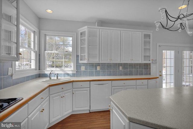 kitchen featuring white cabinetry, tasteful backsplash, sink, hardwood / wood-style flooring, and white dishwasher