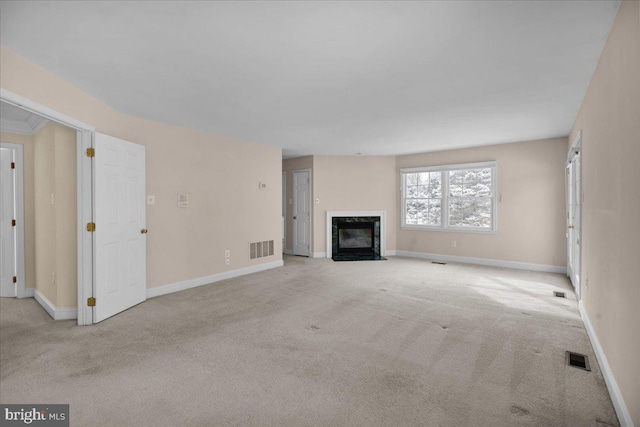 unfurnished living room with light carpet and a high end fireplace