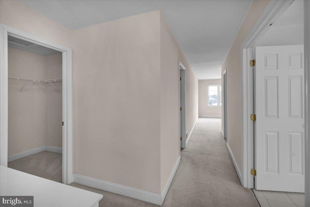 hallway featuring light colored carpet