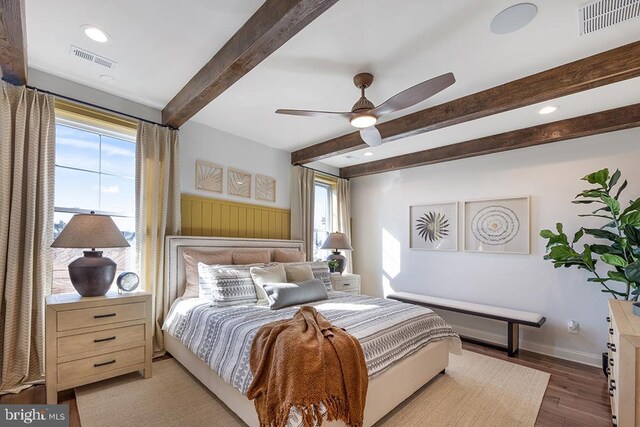 bedroom with beamed ceiling, ceiling fan, and wood-type flooring