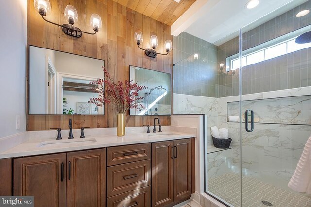 bathroom with beamed ceiling, vanity, a shower with shower door, and wood walls