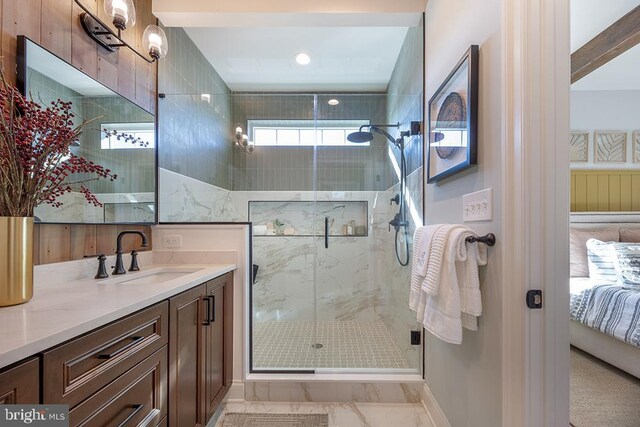 bathroom featuring a shower with shower door and vanity