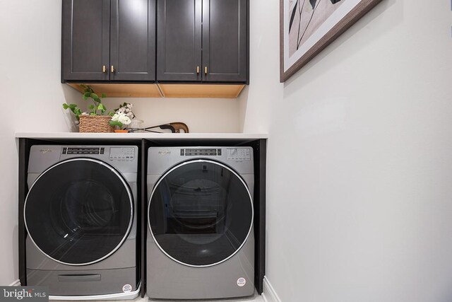 laundry area with cabinets and washer and clothes dryer