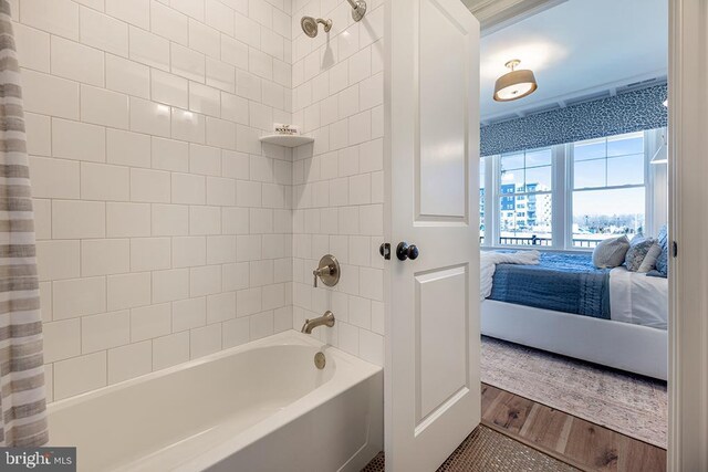 bathroom featuring hardwood / wood-style floors and shower / bathtub combination with curtain