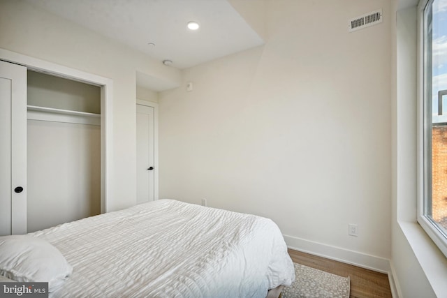 bedroom featuring a closet and dark hardwood / wood-style floors