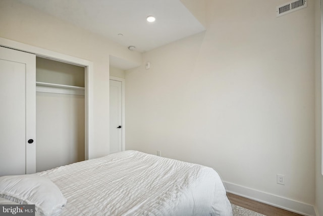 bedroom with a closet and dark hardwood / wood-style floors