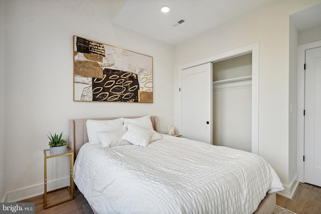 bedroom featuring dark wood-type flooring and a closet