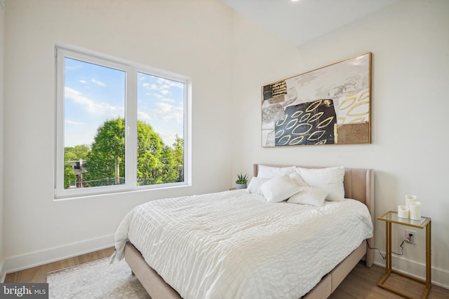 bedroom with wood-type flooring and multiple windows